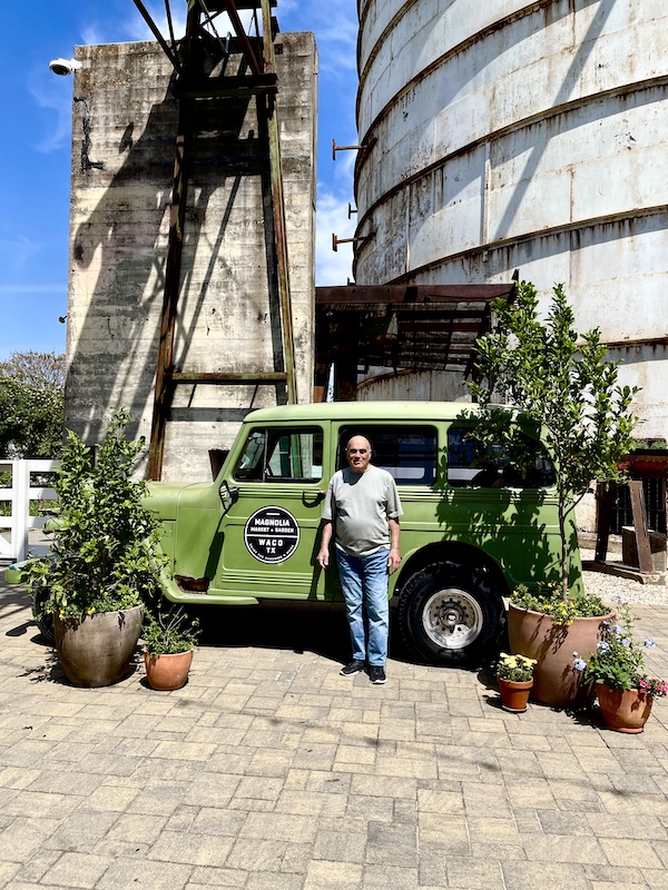 Steve standing beside a lime green Jeep-like vehicle between two trees at The Silos Waco Texas