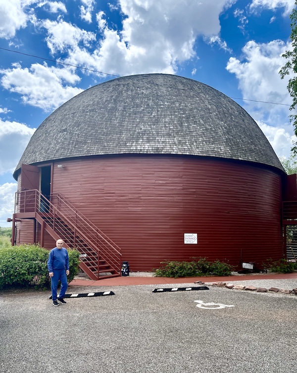 Round red barn with domed roof and blue sky with white puffy clouds is the Arcadia Round Barn Oklahoma