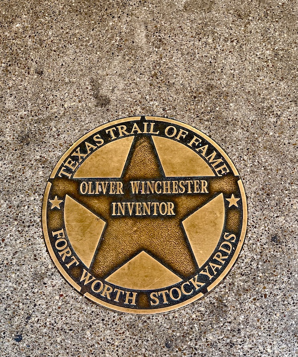 Bronze star embedded in the red brick paver sidewalk at The Stockyards Fort Worth Texas honoring Oliver Winchester