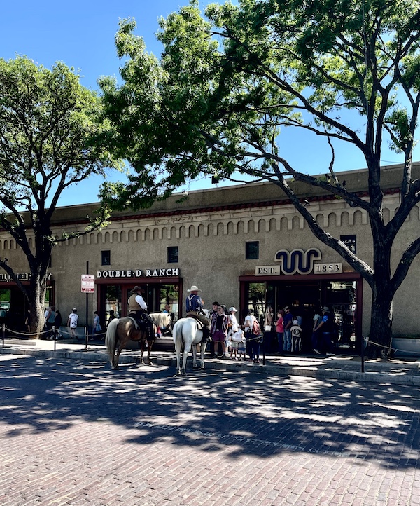 Cowboys on horseback in front of shops at The Stockyards Fort Worth Texas