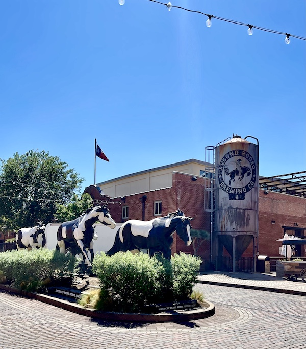 Black and white painted horse statues in front of a brewery at The Stockyards Fort Worth Texas