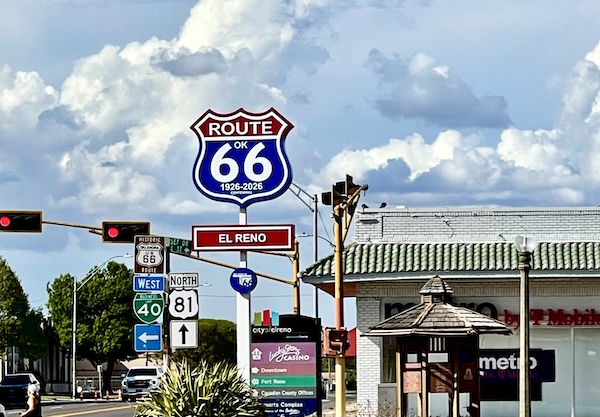 Happy 100 Route 66! Street corner with signs for various routes including Route 66